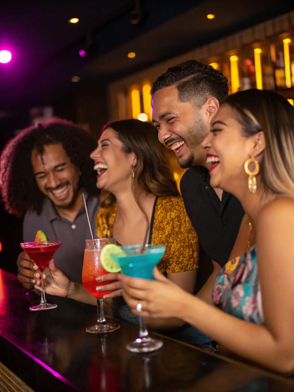 A close-up shot of a group of friends laughing and enjoying cocktails in The Spot's outdoor lounge, showcasing the social atmosphere.